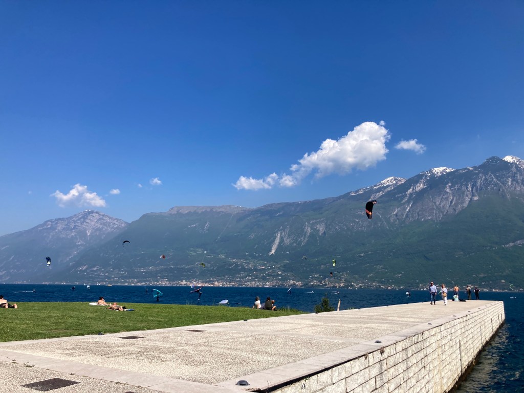 Kitesurfer am Gardasee mit Bergpanorama im Frühling